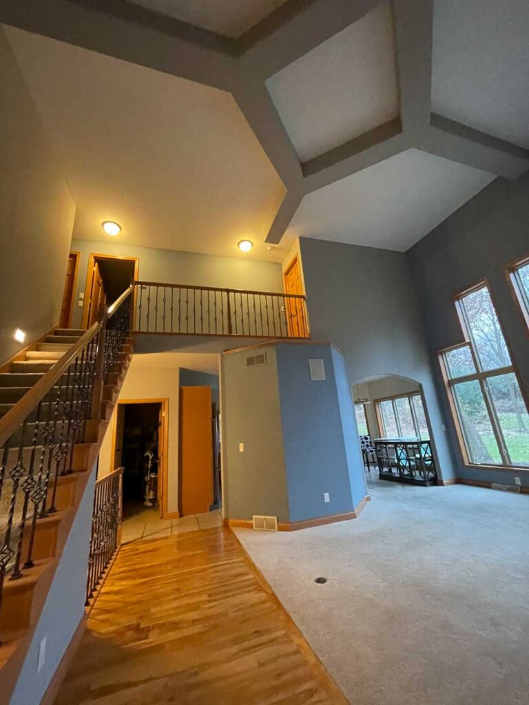 A large open living room with stairs leading to the second floor.