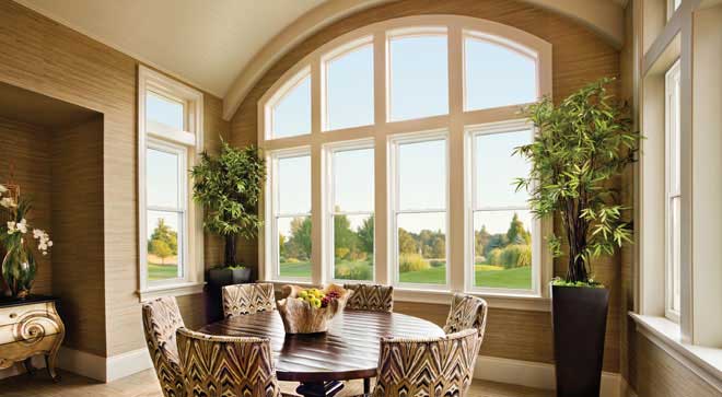 A dining room with large windows and a table