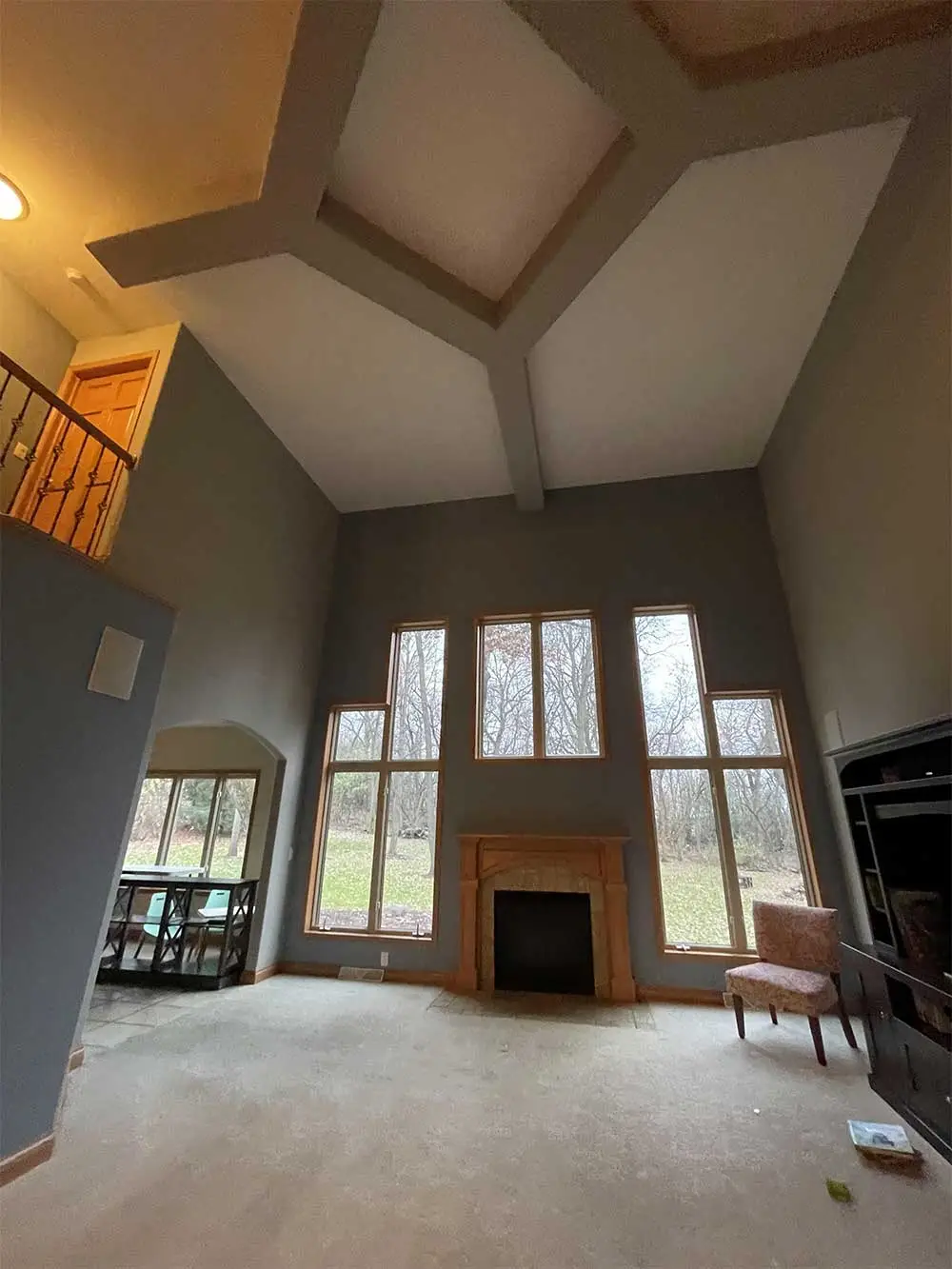 A living room with a fireplace and two windows.