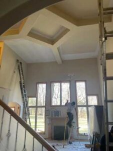 A man painting the ceiling of a house.