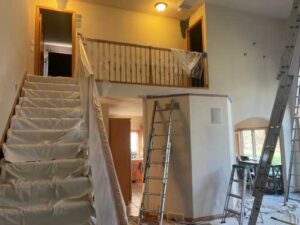 A ladder and some stairs in the middle of a room.