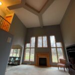 A living room with two large windows and a fireplace.