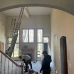 A group of people working on the stairs in a house.