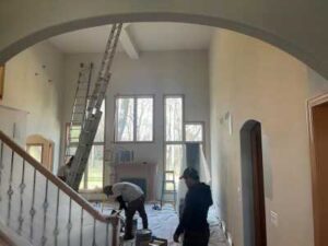 A group of people working on the stairs in a house.