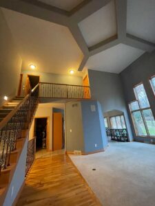 A large open living room with stairs leading to the second floor.